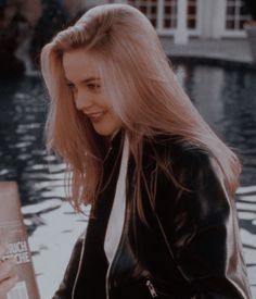 a woman with long blonde hair holding a book