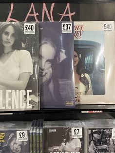 an assortment of cd's for sale on a shelf in a store display case