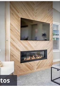 a living room with a tv mounted on the wall and fireplace in front of it