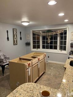 a kitchen with granite counter tops next to a piano in the living room and an open window