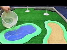 someone is pouring water into a plastic golf hole