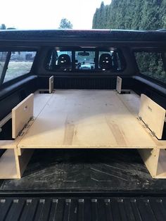 the back end of a pickup truck with an open bed and storage compartment in it