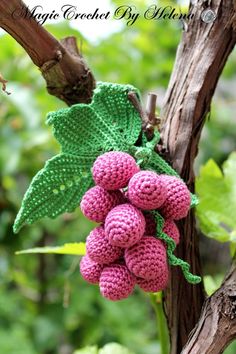 crocheted grapes hanging from a tree branch