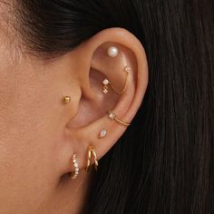 a woman wearing three different ear piercings