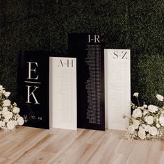 three black and white books on a wooden table with flowers in vases next to them