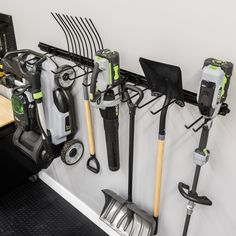 there are many garden tools hanging on the wall