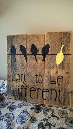 three pieces of wood with birds and words on them