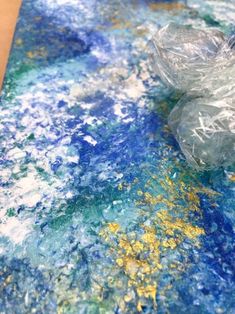 an abstract painting with blue, yellow and white colors on it's surface is shown