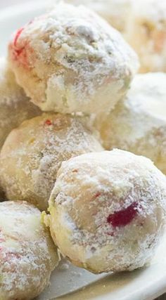 a white plate topped with powdered sugar covered donuts and cranberry sauce