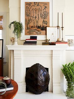 a living room with a fire place and art on the wall