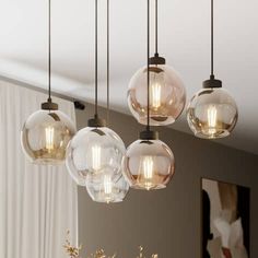 five clear glass globe lights hanging from a ceiling