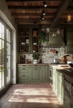 a kitchen filled with lots of green cupboards and counter top next to a window