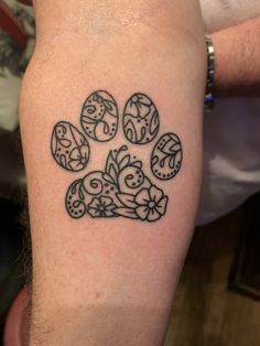 a dog paw tattoo on the left upper arm