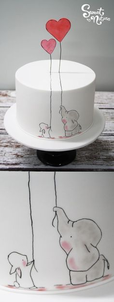 the cake is decorated with an elephant and heart balloon