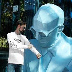 a man standing next to a blue statue with his hand on the face and arm