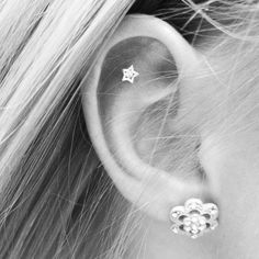 a woman's ear is shown with two small stars in the middle of it