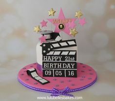 a birthday cake with a movie clapper and stars