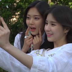 two young women taking pictures with their cell phones