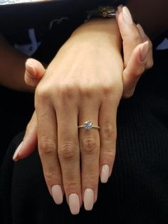 a woman's hand with a diamond ring on her left wrist, holding another person's arm