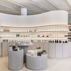 the inside of a store with white walls and shelves filled with different types of bottles