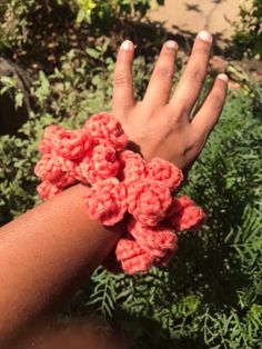 a woman's hand with crochet bracelets on it