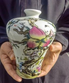 a person holding a vase in their hand