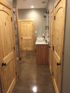 an open door leading to a bathroom with granite counter tops and wooden doors on both sides