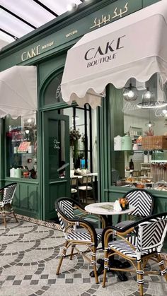 an outdoor cafe with tables, chairs and umbrellas on the sidewalk outside in front of it