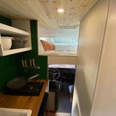 a tiny kitchen with green walls and white cabinets