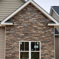 a brick building with two windows and a sign on it