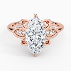 a rose gold ring with a pear shaped diamond in the center and side stones on each band