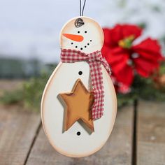 a wooden snowman ornament with a star hanging from it