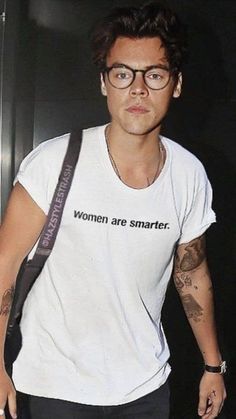 a man with glasses is carrying a bag and wearing a t - shirt that says women are smarter