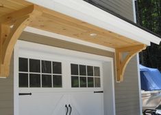 a white garage with an attached wooden roof