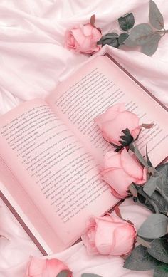 an open book with pink roses on it