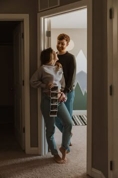 a man and woman standing next to each other holding a skateboard in their hands