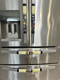 a stainless steel refrigerator with yellow handles and two water dispensers on it