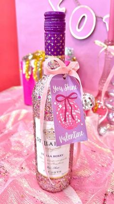 a bottle of wine sitting on top of a table next to a pink sign that says your show valentine