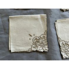 two pieces of cloth with embroidered flowers on them