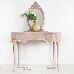 a pink dressing table with mirror and vase on top