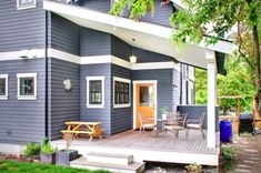 a blue house with a deck and picnic table