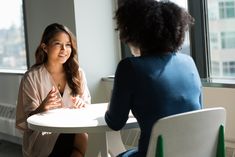 two women sitting at a table talking to each other with the words tips for beating pre - interview jitters