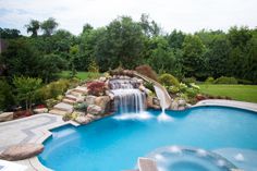 an outdoor pool with waterfall and water features