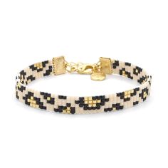 a black and white beaded bracelet with gold clasps on a white background,