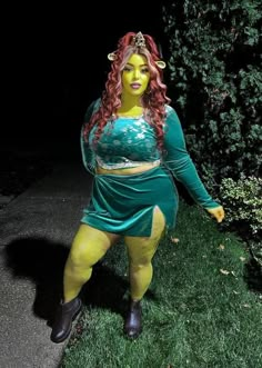 a woman dressed in yellow and green poses for the camera with her hands on her hips