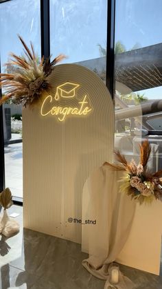 a sign that says congrat on it next to some decorations in front of a window