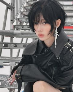 a woman with short black hair sitting down