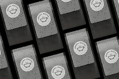 several black and white business cards with coffee logos on them, all lined up in rows