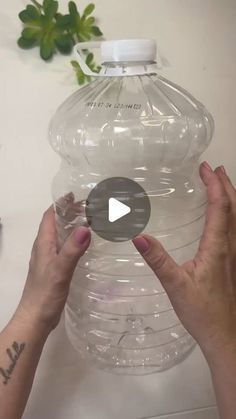 two hands are holding a large plastic water bottle with the lid up and one hand is reaching for it