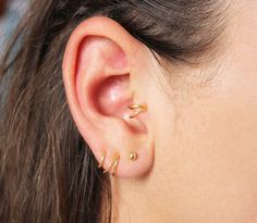 a close up of a person's ear with two piercings on top of it